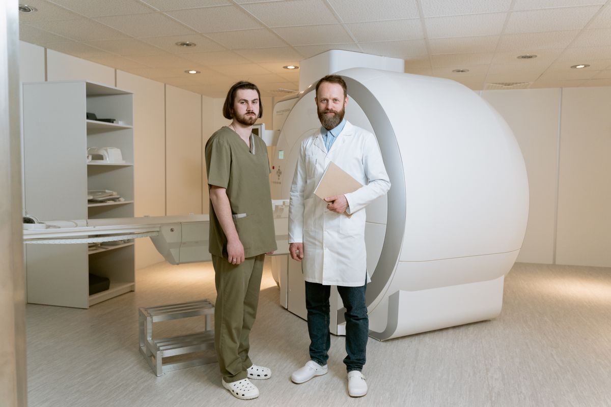 Two imaging professionals standing together in front of an MRI scanner